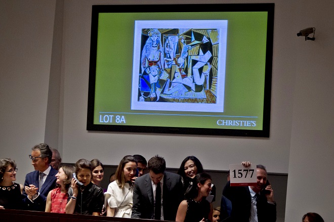 A Christie's employee hold up the winning paddle number for Pablo Picasso's "Les femmes d'Alger (Version 'O')" (Women of Algiers) at Christie's Auction House in the Manhattan borough New York