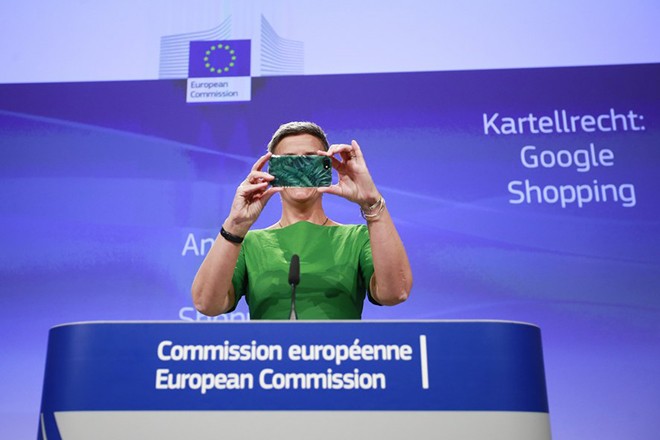epaselect epa06052311 European Commissioner for Competition Margrethe Vestager jokes with her mobile phone during a press conference on an Antitrust case against Google Shopping in Brussels, Belgium, 27 June 2017. The European Commission said it would fine Google with 2.4 billion euros for abusing its dominance as a search engine. EPA/OLIVIER HOSLET