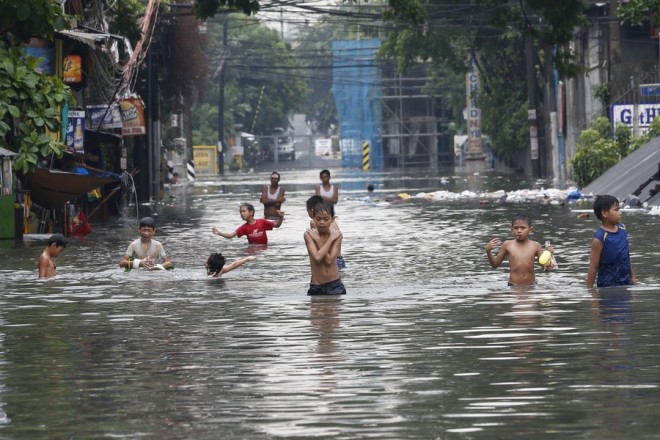 epaselect epa06112061 Filipinos wade in a flooded street in Quezon City, east of Manila, Philippines, 27 July 2017. The center of tropical storm Nesat (local name Gorio) has been estimated at 615 km east of Tuguegarao City, Cagayan province in the northeast area of the Philippines, according to the weather bureau. It is moving with sustained winds of 85 kph near the center and gustiness of up to 105 kph, as it continues to enhance monsoon rains. EPA/ROLEX DELA PENA
