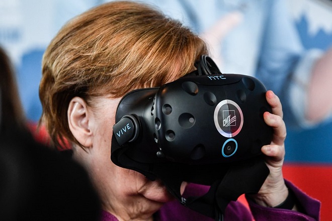 epa06691375 German Chancellor Angela Merkel uses Virtual Reality System during international 'Girl's Day' at the chancellery in Berlin, Germany, 25 April 2018. EPA/FILIP SINGER