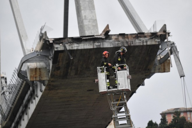 epa06949824 Rescuers at work after a highway bridge collapsed in Genoa, Italy, 14 August 2018. At least 22 people are believed to have died as a large section of the Morandi viaduct upon which the A10 motorway runs collapsed in Genoa. Both sides of the highway fell. Around 10 vehicles are involved in the collapse, rescue sources said. The viaduct gave way amid torrential rain. EPA/LUCA ZENNARO