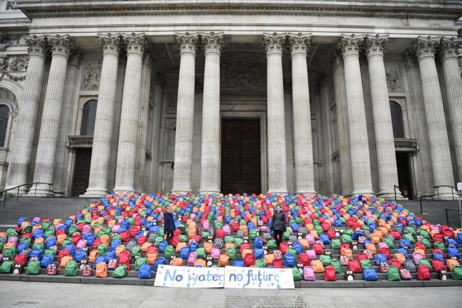 epa07311315 Joana (L) and Jessica (R) Ferreira pose amongst an installation made of 800 schoolbags at St Paul's Cathedral in London, Britain, 23 January 2019. The installation created by the charity WaterAid represents the 800 children who die every day due to dirty water. EPA/NEIL HALL