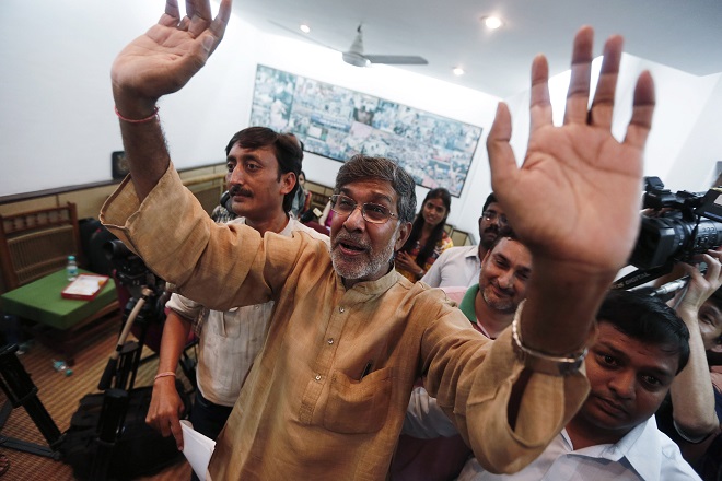 Indian children's right activist Satyarthi waves to the media at his office in New Delhi