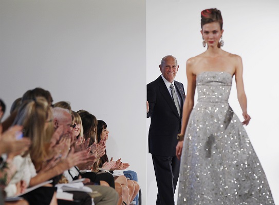 Designer Oscar De La Renta watches a model as she walks the runway during a show of his Spring/Summer 2013 collection during New York Fashion Week