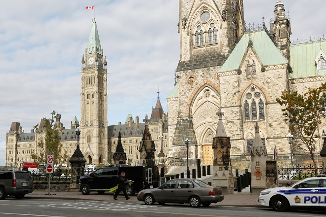 Police officers control traffice on Parliament Hilll following a shooting incident in Ottawa
