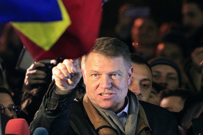 Romanian presidential candidate Klaus Iohannis celebrates his victory in the election run-off, with protesters in central Bucharest