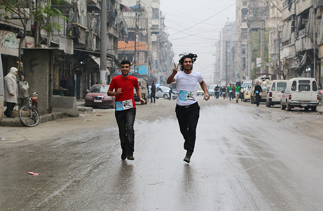 Participants compete in a running race along a street in Aleppo's Bustan al-Qasr neighbourhood