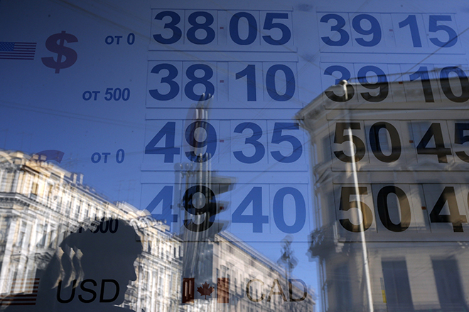 A woman is reflected in a window with a board displaying currency exchange rates in St. Petersburg