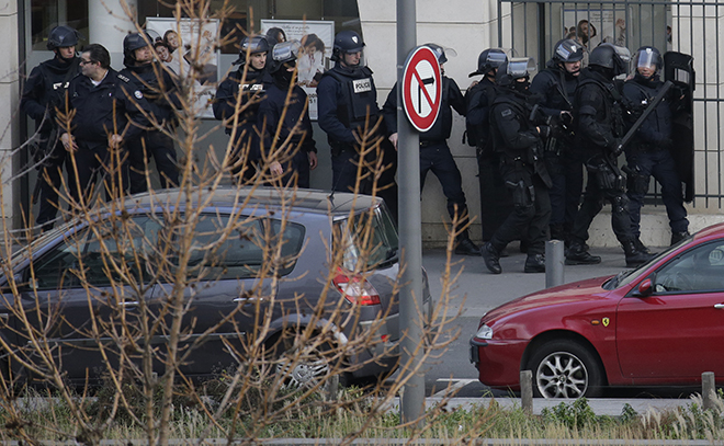 Members of the French police forces secure the area next to the post office in Colombes outside Paris, were an armed gunman is holding hostages