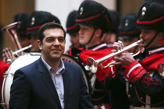 Alexis Tsipras reviews the honour guard as he arrives for a meeting with Matteo Renzi at Chigi palace in Rome