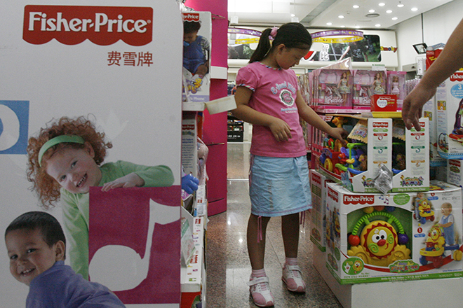 A girl looks at Fisher-Price toys at a store in Beijing