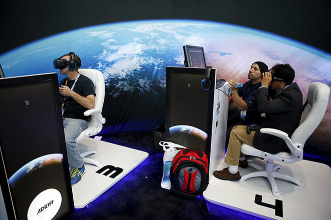 People wear Oculus VR headsets as they play Three One Zero's "Adrift" video game at the Electronic Entertainment Expo, or E3, in Los Angeles, California, United States, June 16, 2015. REUTERS/Lucy Nicholson  - RTX1GSQF