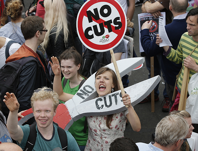 Demonstrators march during an anti-austerity protest in central London, Britain June 20, 2015. Tens of thousands of protesters marched through central London on Saturday to demonstrate against the newly re-elected Conservative government's plans for public spending cuts. REUTERS/Peter Nicholls  - RTX1HDGZ