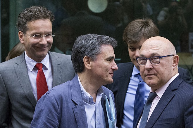Newly appointed Greek Finance Minister Euclid Tsakalotos (C) is welcomed by Eurogroup President Jeroen Dijsselbloem (L) and French Finance Minister Michel Sapin at a euro zone finance ministers meeting on the situation in Greece in Brussels, Belgium, July 7, 2015. Greece faces a last chance to stay in the euro zone on Tuesday when Prime Minister Alexis Tsipras puts proposals to an emergency euro zone summit after Greek voters resoundingly rejected the austerity terms of a defunct bailout. REUTERS/Yves Herman  - RTX1JDMY