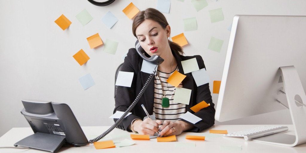 Studio shot of young woman working in office covered with adhesive notes