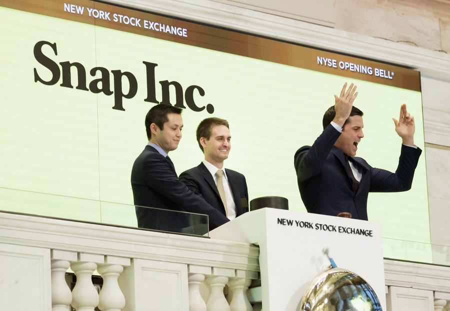 epa05825218 Snapchat co-founders Bobby Murphy (L) and Evan Spiegel (C) ring the opening bell while standing with Thomas W. Farley (R), the President of the NYSE, during the initial public offering of Snap Inc, the parent company of Snapchat, at the New York Stock Exchange in New York, New York, USA, 02 March 2017. Snap Inc. is being priced at 17 US dollars per share which gives the company a value of nearly 24 billion (USD).  EPA/JUSTIN LANE