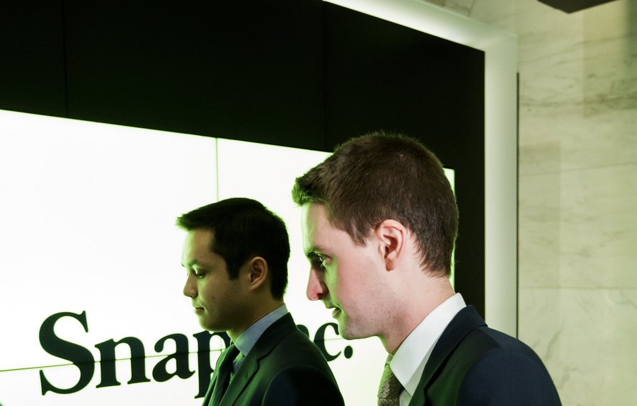 epa05825256 Snapchat co-founders Bobby Murphy (L) and Evan Spiegel (C) head to ring the opening bell before the initial public offering of Snap Inc, the parent company of Snapchat, at the New York Stock Exchange in New York, New York, USA, on 02 March 2017. Snap Inc. is being priced at $17 per share which gives the company a value of nearly $24 billion (USD).  EPA/JUSTIN LANE