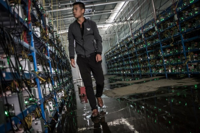epa06062677 (06/26) Tibetan Bitcoin mine manager Kun walks in between aisles of mining machines in a Bitcoin mine in Sichuan Province, China, 26 September 2016. Kun is the mine's manager as well as one of its investors. He learned about Bitcoin through a friend and started investing in 2015. China, the world's leader in Bitcoin mining, is dominating both the currency's generation and the global trade in the currency. Sichuan has become known as 'the capital of bitcoin mining' as entrepreneurial Chinese set up 'mines' there due to its abundance of hydropower, perfect for the high electricity needs of the large number of computers required for Bitcoin mining. Bitcoin mines are buildings with warehouse-like structures equipped with massive numbers of microprocessors with which 'miners' solve complex math problems and are rewarded in the digital currency. The industry exists in a legal gray zone in China, and the miners in this story, concerned about attention from the government, asked not to have their full names or the names of the villages where their mines are located mentioned in this story. EPA/LIU XINGZHE/CHINAFILE ATTENTION: For the full PHOTO ESSAY text please see Advisory Notice epa06062671