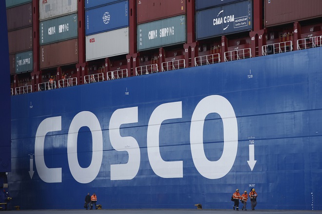 Λιμενεργάτες περπατούν μπροστά από το πλοίο TAURUS, του μεγαλύτερου πλοίου μεταφοράς εμπορευματοκιβωτίων που κατασκευάστηκε ποτέ στην Κίνα, στις εγκαταστάσεις της COSCO PCT στο λιμάνι του Πειραιά, Πειραιάς Δευτέρα 26 Φεβρουαρίου 2018. ΑΠΕ-ΜΠΕ/ΑΠΕ-ΜΠΕ/ΓΙΑΝΝΗΣ ΚΟΛΕΣΙΔΗΣ