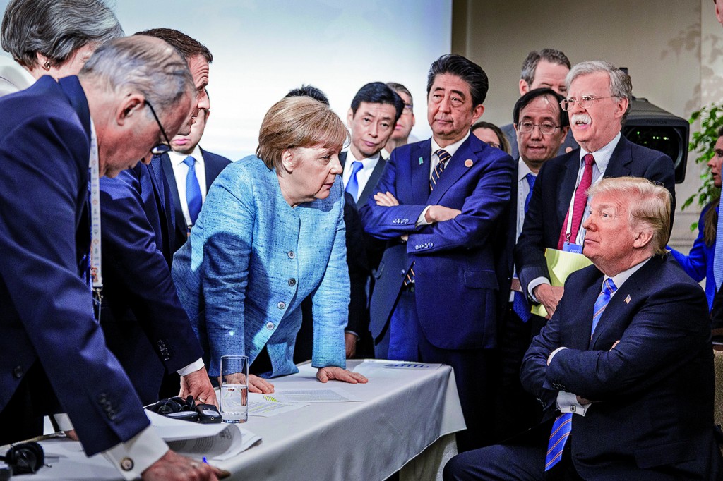 CHARLEVOIX, CANADA - JUNE 9:   In this photo provided by the German Government Press Office (BPA), German Chancellor Angela Merkel deliberates with US president Donald Trump on the sidelines of the official agenda on the second day of the G7 summit on June 9, 2018 in Charlevoix, Canada. Also pictured are (L-R) Larry Kudlow, director of the US National Economic Council, Theresa May, UK prime minister, Emmanuel Macron, French president, Angela Merkel, Yasutoshi Nishimura, Japanese deputy chief cabinet secretary, Shinzo Abe, Japan prime minister, Kazuyuki Yamazaki, Japanese senior deputy minister for foreign affairs, John Bolton, US national security adviser, and Donald Trump. Canada are hosting the leaders of the UK, Italy, the US, France, Germany and Japan for the two day summit. (Photo by Jesco Denzel /Bundesregierung via Getty Images)