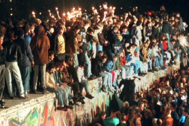 Berliners celebrate on top of the wall on November 9th DPA