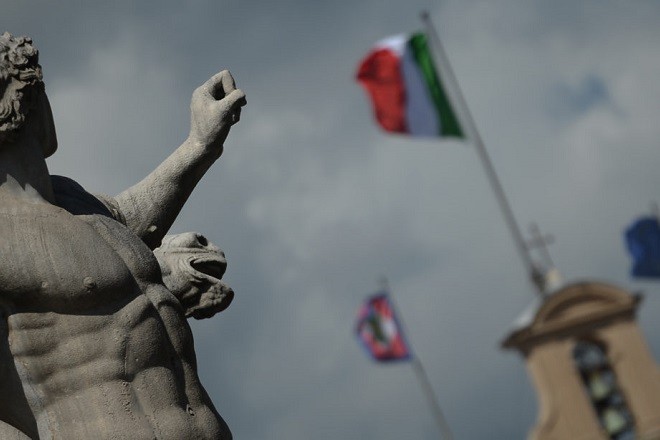 Picture of a statue in front of the Quirinale palace, Italian presidential residence, with the Italian and the European Union flag on the roof, on March 21, 2013 in Rome. Italian President Giorgio Napolitano began two days of consultations with political leaders yesterday in a bid to determine who should be given the mandate to form a new government in the eurozone's third largest economy.    AFP PHOTO / FILIPPO MONTEFORTE        (Photo credit should read FILIPPO MONTEFORTE/AFP/Getty Images)