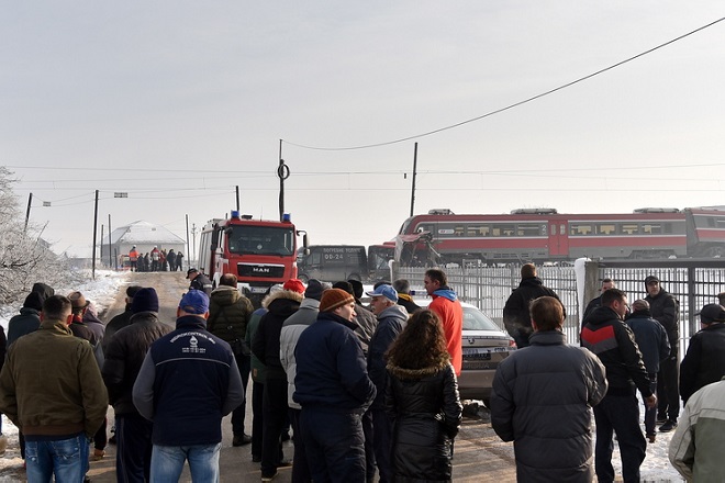 epa07243209 People and emergency vehicle near the crash scene between a bus and a train at a railway crossing in the village of Donje Medjurovo, some 10km from the city of Nis, Serbia, 21 December 2018. According to reports, the train slammed into a bus, which transported passengers from Donje Medjurovo to Nis, at a railway crossing that did not reportedly have a level crossing. Five people were killed and over 20 were injured, media added.  EPA/DJORDJE SAVIC
