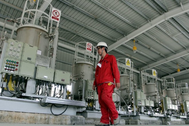 epa04388401 A Chinese oil worker walks at al-Halfaya refinery in Amara, some 450 km south of Baghdad, Iraq, 06 September 2014. A group led by PetroChina Company Ltd. has begun work on the second phase of development of giant Halfaya oil field in Iraq. The total production is said to reach 600,000 barrels when the third phase is complete at the end of 2016, an official in PetroChina Company said. EPA/STR