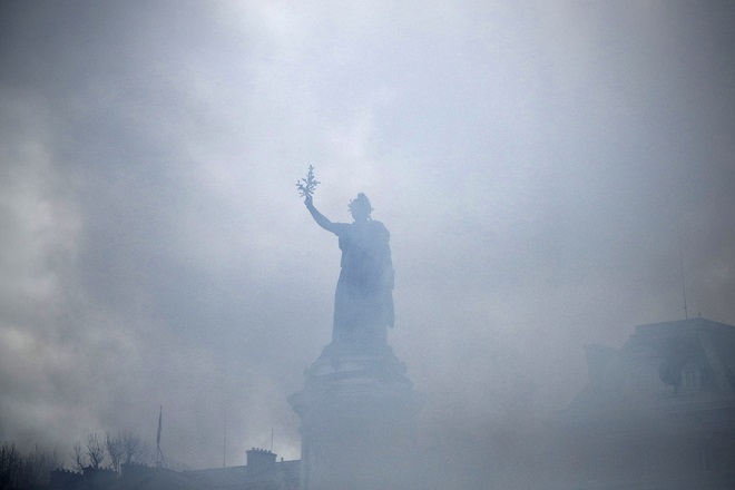 epa07338597 The statue of the Republic Square in the tear gaz smokes as clashes erupt between Protesters from the 'Gilets Jaunes' (Yellow Vests)and the anti-riot police during the 'Act XII' demonstration (the 12th consecutive national protest on a Saturday) dedicated to the victims of the movement in Paris, France, 02 February 2019. The so-called 'gilets jaunes' (yellow vests) is a grassroots protest movement with supporters from a wide span of the political spectrum, that originally started with protest across the nation in late 2018 against high fuel prices. The movement in the meantime also protests the French government's tax reforms, the increasing costs of living and some even call for the resignation of French President Emmanuel Macron.  EPA/YOAN VALAT